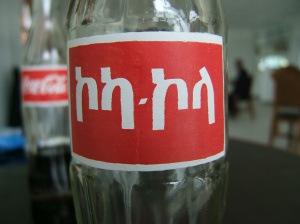 Image showing a bottle of Coca-Cola, a global brand by the leading beverage companies, Coca-Cola, in Amharic.